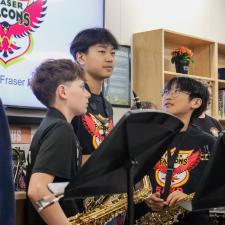 Students holding instruments prepare to preform in front of the audience