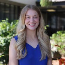 Professional headshot of female employee standing outside.